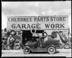Vintage auto parts store with classic car and tires displayed outside