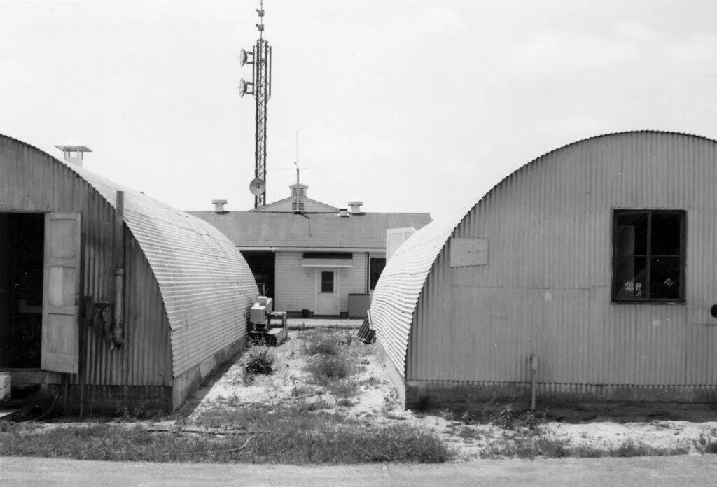 Industrial facility with arched metal buildings and communication tower