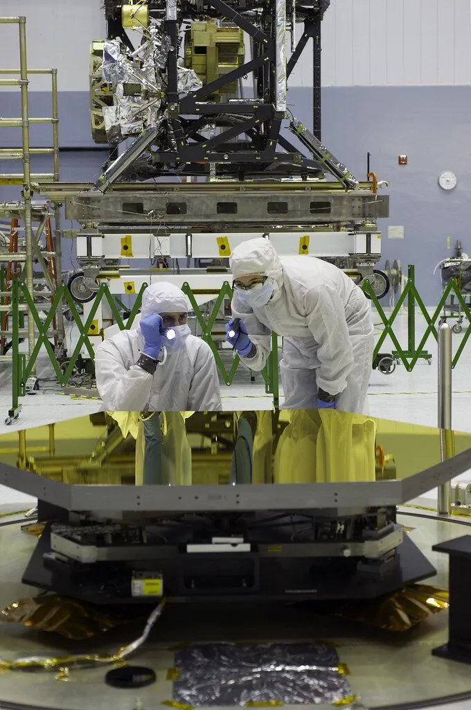 Technicians inspecting automotive components in a cleanroom quality control environment